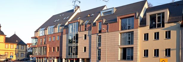 Straßenseite mit mehrstöckigen Wohnhäusern in moderner Architektur bei Tageslicht